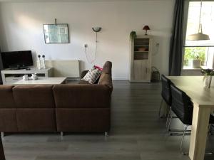 uma sala de estar com um sofá castanho e uma mesa em Vakantie aan de Lauwers em Gerkesklooster