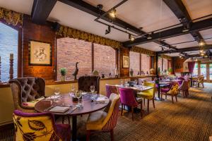 a restaurant with tables and chairs and a bar at The Feathers Hotel, Ledbury - The Coaching Inn Group in Ledbury