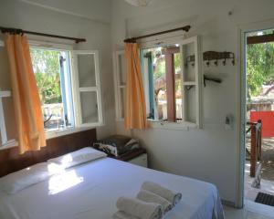 a bedroom with a white bed and white walls at Santorini Camping/Rooms in Fira