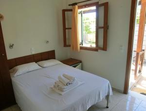 a bedroom with a bed and a window at Santorini Camping/Rooms in Fira