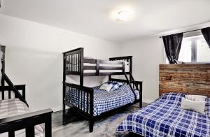 een slaapkamer met 2 aparte bedden en een houten stapelbed bij Chalet 29 Chemin Blanc by Les Chalets Alpins in Stoneham