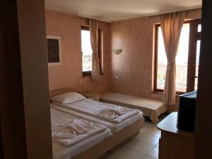 a bedroom with two beds and a window at Guest House Val and Kate in Sveti Vlas +10 photos