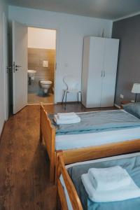 a bedroom with two beds and a bathroom with a toilet at Three Corners in Grenzach-Wyhlen