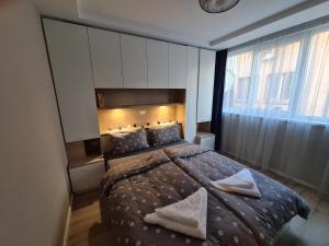 een slaapkamer met een groot bed met 2 kussens bij Modern and cozy flat in the city center in Varna