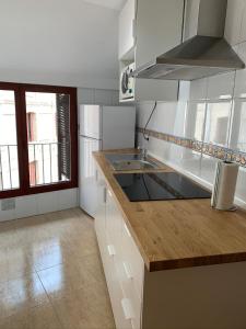 cocina con armarios blancos y encimera de madera en Apartamento dúplex en el centro de Huesca en Huesca