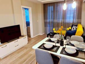 a living room with a table and a tv at Modern and cozy flat in the city center in Varna City