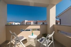 a patio with two chairs and a table on a balcony at Apartman Mares in Krk