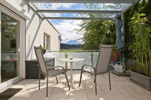 a patio with a table and chairs and a window at Am Seerosenweiher in Innsbruck