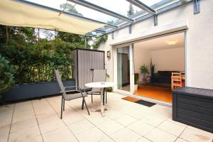 a patio with a table and chairs and an umbrella at Am sonnigen Waldrand in Innsbruck