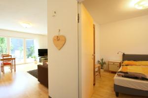Zimmer mit einem Bett und einer Herzuhr an der Wand in der Unterkunft Am sonnigen Waldrand in Innsbruck
