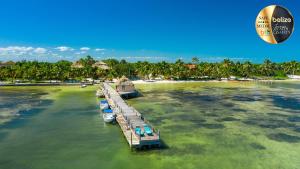 a dock with boats in the water next to a beach at Portofino Beach Resort-An Authentic Island Escape! in San Pedro