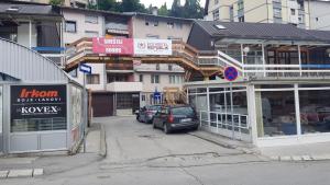 a street with cars parked in front of buildings at Apartman Galerija in Užice