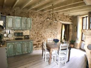 Saint-MacaireにあるMaison atypique dans cité médiévaleの石壁のキッチン(木製テーブル付)