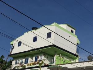 un edificio blanco y verde con ventanas azules en Apartamento Tolu en Tolú
