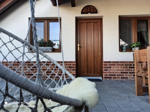 a house with a wooden door and a porch at Sklípek u Svobodů in Velké Bílovice