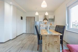 ファジャナにある2 BEDROOM APARTMENT PEROJの木製のテーブルと椅子のあるキッチンとダイニングルーム