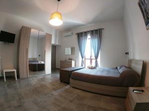 a bedroom with a bed and a large window at B&B Tra Monti e Mare in Ogliastro Cilento