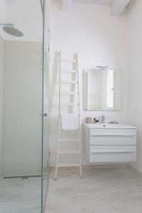 uma casa de banho com uma escada, um lavatório e um espelho. em Affittacamere Ortygia Inn Rooms con Terrazza sul Mare e Jacuzzi em Siracusa