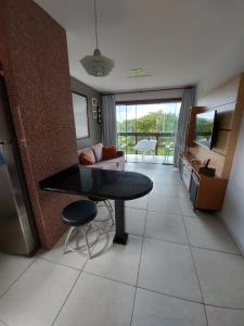 apartamento em serra negra - bezerros في بيزيروس: مطبخ وغرفة معيشة مع طاولة وأريكة