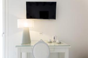 a white desk with a lamp and a white chair at Affittacamere Ortygia Inn Rooms con Terrazza sul Mare e Jacuzzi in Siracusa