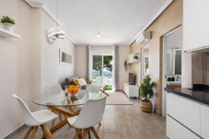 a kitchen and dining room with a glass table and white chairs at Apartment with lovely views in Ciudad Quesada in Ciudad Quesada