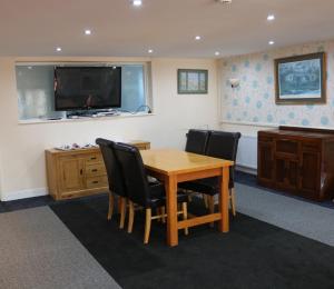 a dining room with a table and chairs and a television at Lennard House in Folkestone