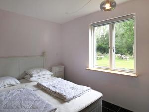 um quarto branco com uma cama e uma janela em Two-Bedroom Holiday home in Jægerspris 1 em Hornsved