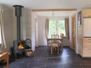 uma cozinha e sala de jantar com um fogão a lenha em Two-Bedroom Holiday home in Jægerspris 1 em Hornsved