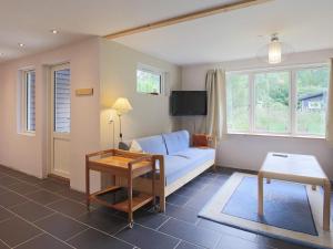 - un salon avec un canapé bleu et une table dans l'établissement Two-Bedroom Holiday home in Jægerspris 1, à Hornsved
