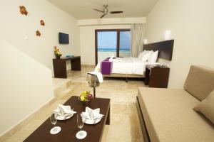 a living room with a bed and a couch at Akumal Bay Beach & Wellness Resort in Akumal