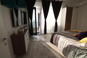 um quarto com uma cama, uma cómoda e janelas em PANORAMIS PROMENADA-CEZAR em Mamaia Nord – Năvodari