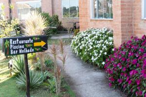 um sinal em frente a um jardim com flores em Hotel Recanto Maria Bonita em Socorro