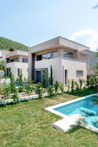 a house with a swimming pool in front of it at SunBlue Boutique Villas in Skala Rachoniou