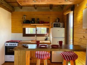 faro في بونتا ديل ديابلو: مطبخ مع كونتر مع الكراسي وثلاجة