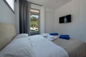 SunBlue Boutique Villas في سكالا راخونيو: غرفة نوم عليها سرير وفوط