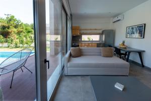 a living room with a couch next to a kitchen at SunBlue Boutique Villas in Skala Rachoniou +80 photos