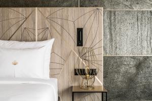 sypialnia z białym łóżkiem i drewnianą ścianą w obiekcie Nosalowy Park Hotel & Spa w Zakopanem