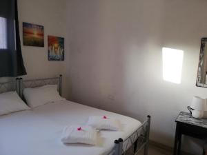 a bedroom with a bed with two white towels on it at La casa del melograno in Marsala