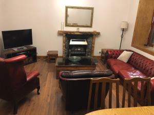 a living room with a couch and a fireplace at Spacious comfortable flat in Scalloway, Shetland. in Scalloway