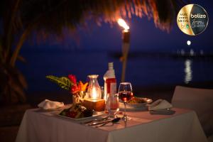 a table with a candle and a plate of food and wine at Portofino Beach Resort-An Authentic Island Escape! in San Pedro