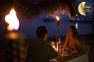 a man and a woman sitting at a table with wine glasses at Portofino Beach Resort-An Authentic Island Escape! in San Pedro