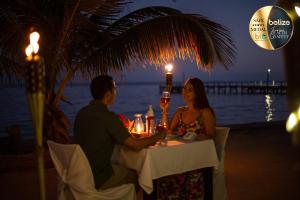 a man and woman sitting at a table with a glass of wine at Portofino Beach Resort-An Authentic Island Escape! in San Pedro