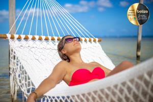 a woman laying in a hammock on the beach at Portofino Beach Resort-An Authentic Island Escape! in San Pedro