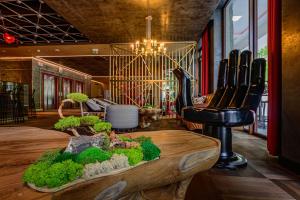 Cette chambre comprend une table avec des plantes et une chaise. dans l'établissement Nosalowy Park Hotel & Spa, à Zakopane