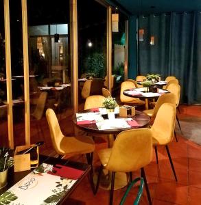 grupa stołów i krzeseł w restauracji w obiekcie Hotel Ristorante Paradise w mieście Santa Maria di Licodia