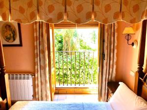 1 dormitorio con 1 cama y ventana con balcón en Hostal Posada La Panadera, en Sepúlveda