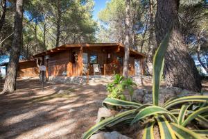a log cabin in the woods with a tree at Tenuta del Barco in Pulsano