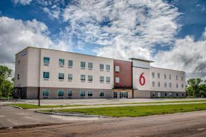 a large white building with a red c on it at Motel 6 North Platte - East in North Platte