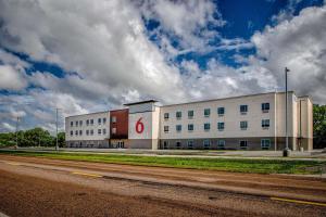 un grande edificio bianco con un cartello rosso di Motel 6 North Platte - East a North Platte