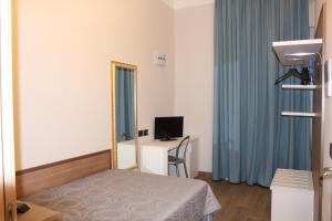 1 dormitorio con cama, espejo y escritorio en House Beatrice Milano, en Milán